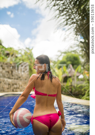 Slender girl model in a sexy pink swimsuit plays 59013658