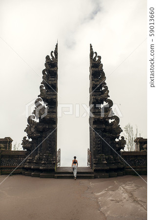 Slender girl near the huge gate of a Balinese 59013660