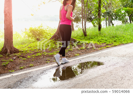 Woman exercise walking in the park with hand holding cell phone. 59014066