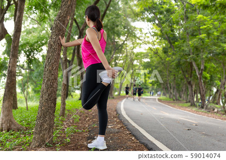 Woman stretching here leg muscle get ready for exercise in the park. Woman stretching here leg muscle get ready for exercise in the park. 59014074