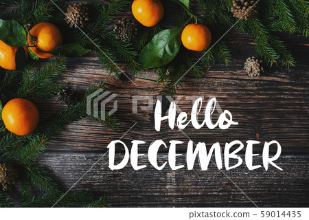 wooden background and tangerines with cones and text Hello December 59014435