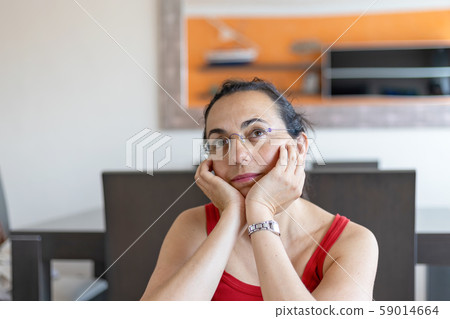 Pretty Spanish woman thinking anything at home 59014664