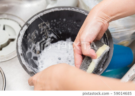 Woman washing the inner pot of rice cooker 59014685