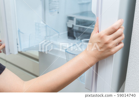 A woman who opens a refrigerator A woman who opens a refrigerator 59014740