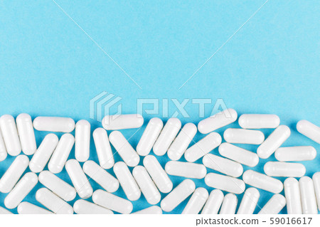 white medicine capsules on blue background with copy space white medicine capsules on blue background with copy space 59016617