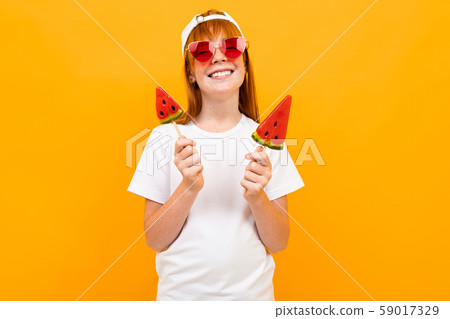red-haired beautiful girl in a white T-shirt on a background of an orange wall, mockup, emotional red-haired beautiful girl in a white T-shirt on a background of an orange wall, mockup, emotional 59017329