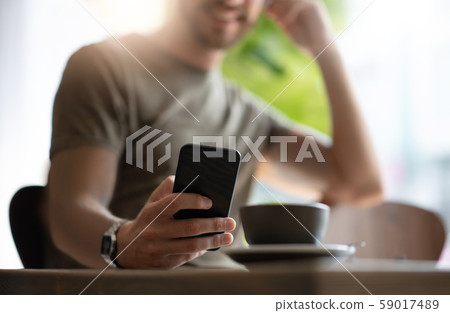Beard man using smartphone on wooden table at the Beard man using smartphone on wooden table at the 59017489