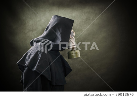 Man in a gas mask and hooded cloak. Environment pollution. Man in a gas mask and hooded cloak. Environment pollution. 59018676