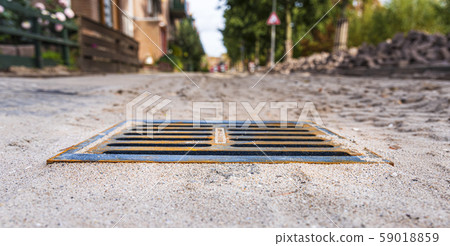 Drain grating. Building material for the road. Laying paving slabs in the city. Repair work. 59018859