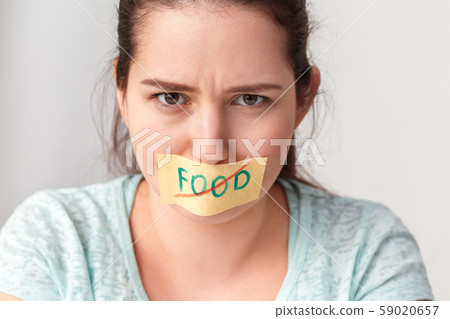 Body Care. Chubby girl mouth patched with sticker standing in kitchen looking camera agressive close Body Care. Chubby girl mouth patched with sticker standing in kitchen looking camera agressive close 59020657
