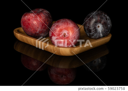 Fresh red plum isolated on black glass 59023758