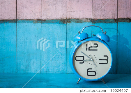 Blue vintage alarm clocks on blue wooden table and light blue and pink background wall Blue vintage alarm clocks on blue wooden table and light blue and pink background wall 59024407