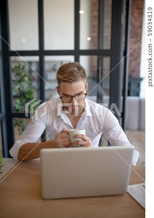 Businessman drinking coffee in the morning and watching news 59034819