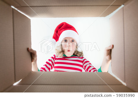 Surprised child unpack Christmas gift box 59035990