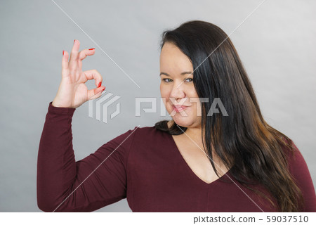 Woman making thumb up gesture 59037510
