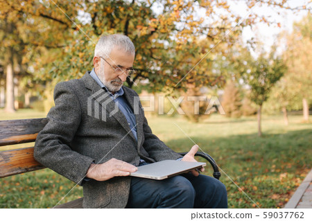 Grandfather close laptop after work in the park 59037762
