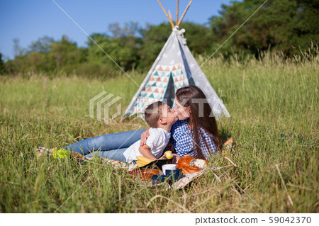 Mom and young son eat on a picnic in the woods 59042370
