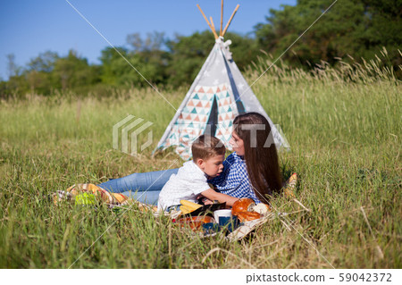 Mom and young son eat on a picnic in the woods 59042372