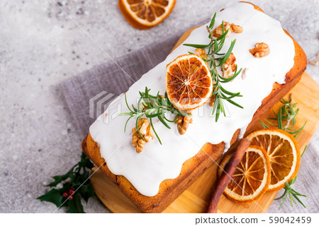 Fruit cake dusted with icing, nuts and dry orange 59042459