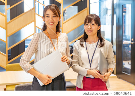 有一台計算機的兩個少婦在共享辦公室 有一台計算機的兩個少婦在共享辦公室 59043641