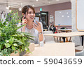 Young woman listening to music with a wireless earphone with a smile during the break 59043659