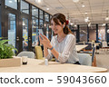 Young woman listening to music with a wireless earphone with a smile during the break 59043660