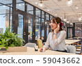 Young woman listening to music with a wireless earphone with a smile during the break 59043662