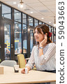 Young woman listening to music with a wireless earphone with a smile during the break 59043663