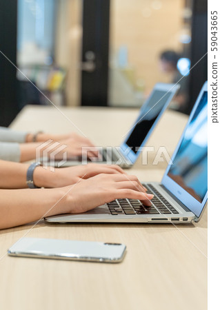 Hands and smartphones working on a computer 59043665