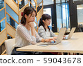Two young women working dissatisfied towards a personal computer 59043678