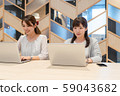 Two young women working with a smile towards the computer 59043682