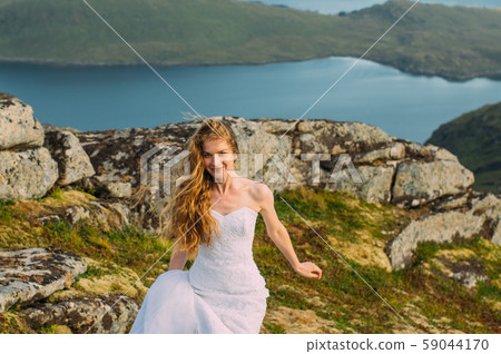 Bride in wedding dress in mountains looking  59044170