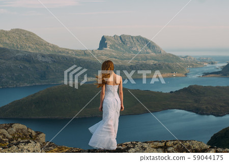 Back of girl in wedding dress staying in mountains 59044175