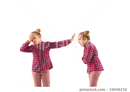 Young handsome girl arguing with herself on white studio background. Young handsome girl arguing with herself on white studio background. 59046258