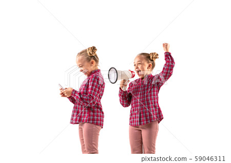 Young handsome girl arguing with herself on white studio background. Young handsome girl arguing with herself on white studio background. 59046311
