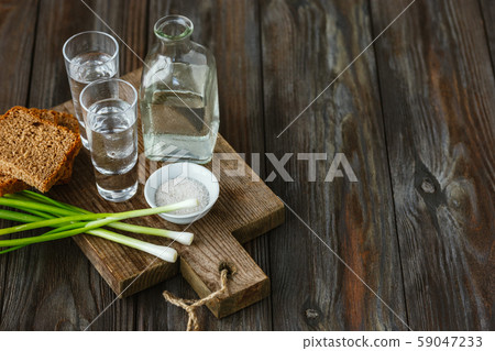 Vodka and traditional snack on wooden background Vodka and traditional snack on wooden background 59047233