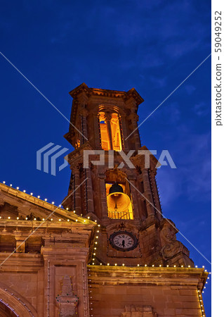 Church facade with fairy light against blue sky Church facade with fairy light against blue sky 59049252