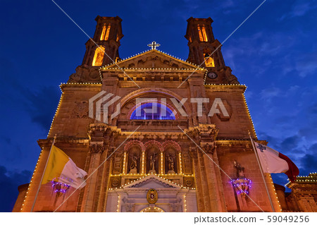 Church facade with fairy light against blue sky 59049256