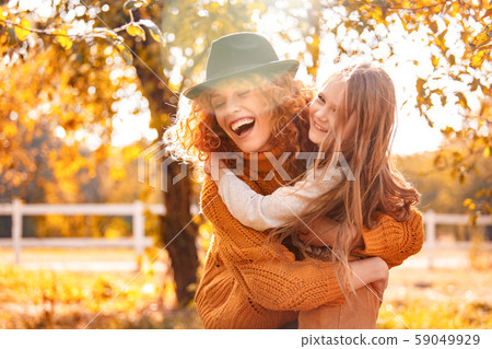 Young adult mother hugging her child girl outdoor Young adult mother hugging her child girl outdoor 59049929