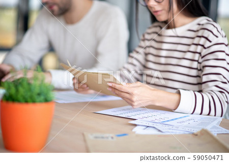 Close up of wife holding envelopes with letters Close up of wife holding envelopes with letters 59050471