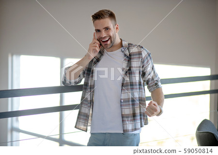 Handsome cheerful man feeling amazed after hearing good news 59050814