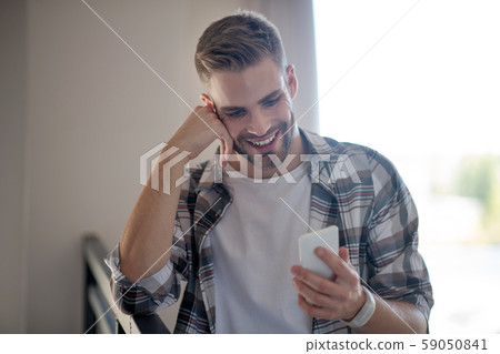 Cheerful bearded man reading message from girlfriend Cheerful bearded man reading message from girlfriend 59050841