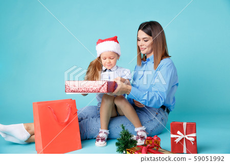 New Year time concept. Mom and kid together sitting with gifts. New Year time concept. Mom and kid together sitting with gifts. 59051992