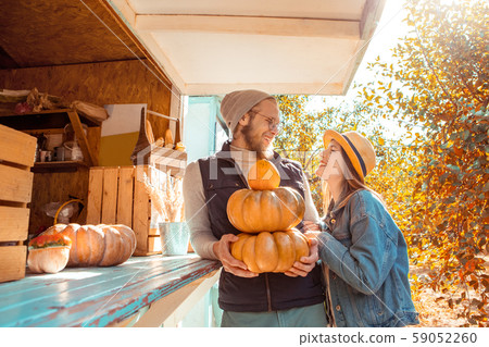 Halloween Preparaton Concept. Young couple decorating house with pumpkins looking at each other 59052260