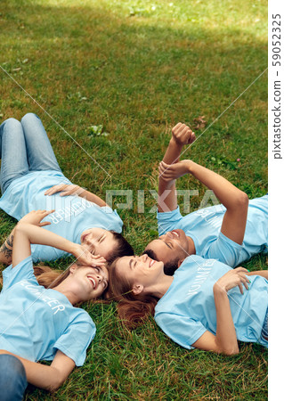 Volunteering. Young people volunteers outdoors lying resting laughing cheerful 59052325