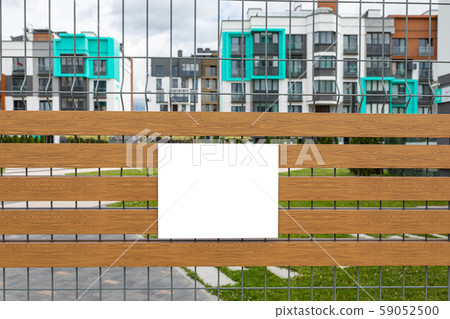 Blank white tablet on metal mesh gate 59052500