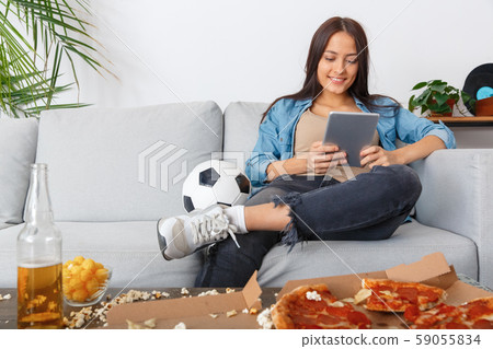 Young woman sport fan watching match on digital tablet Young woman sport fan watching match on digital tablet 59055834