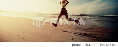 Fitness woman runner running on sunrise beach 59058239
