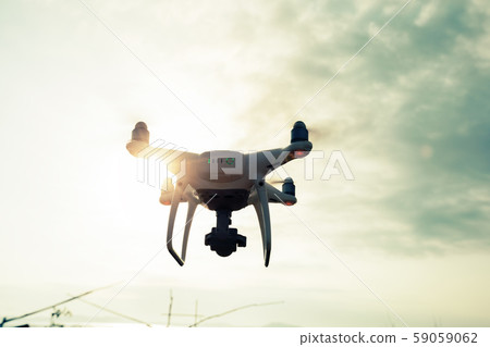 Drone flying in the air under cloudy sky 59059062