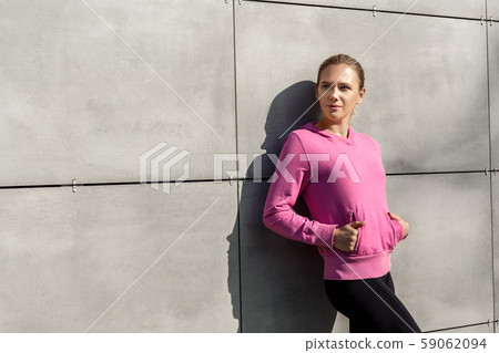 Healthy Lifestyle. Young woman hands in pockets standing isolated leaning on wall outdoors autumn 59062094